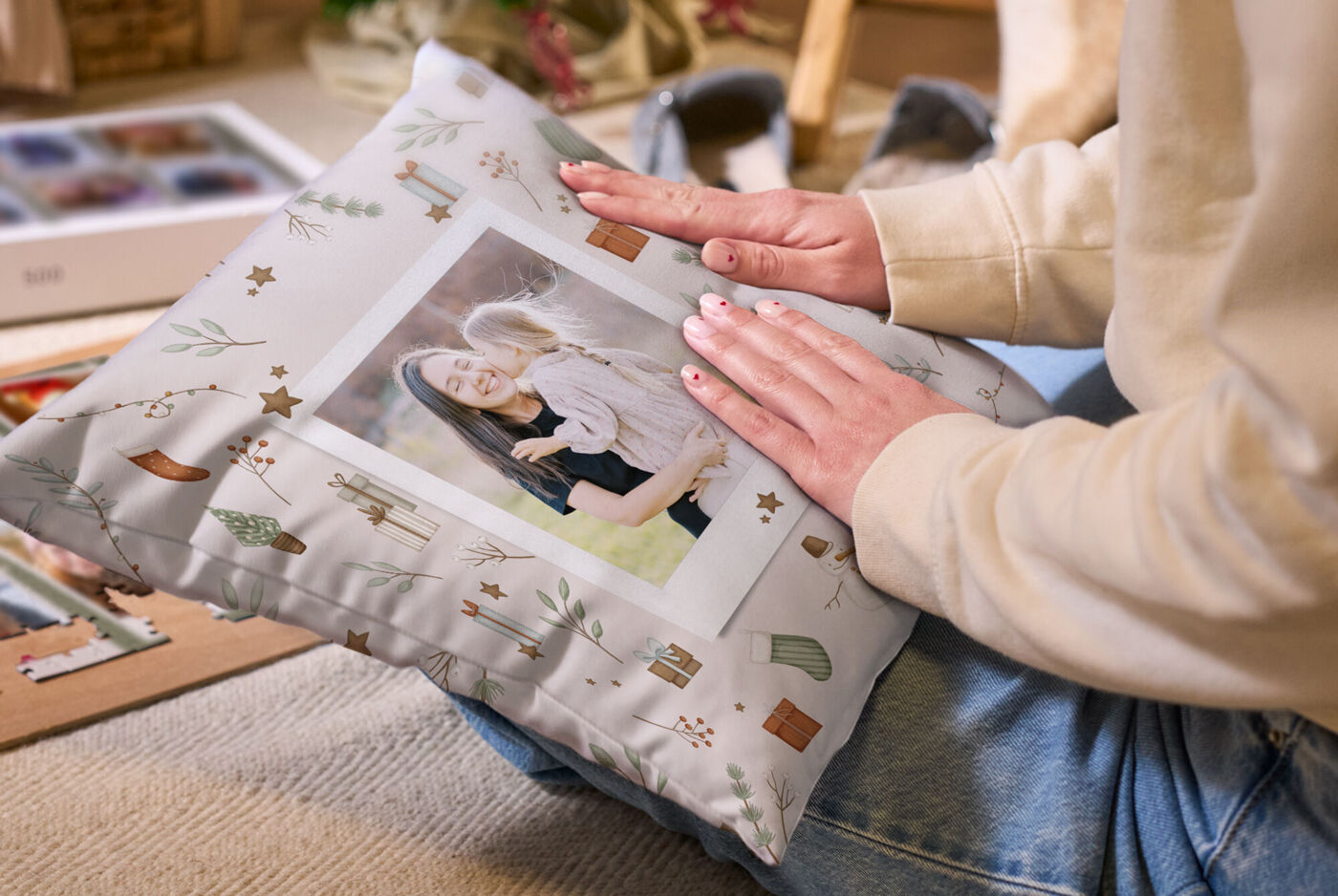 Hände streichen über ein Kissen, das mit einem Weihnachtsdesign und dem Foto einer Frau mit Kind bedruckt ist