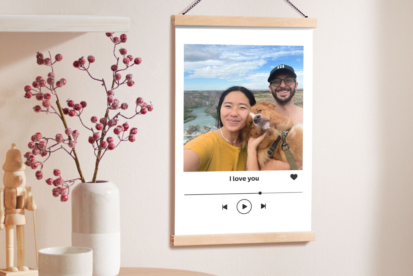 Ein Poster mit Holzleiste in Eiche hängt an einer Wand und zeigt ein Foto eines Paares mit Hund mit einer Landschaft im Hintergrund