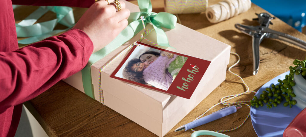 Ein Geschenk liegt auf einem Tisch und wird mit einem Schleifenband und einem Foto mit Weihnachtsdesign dekoriert