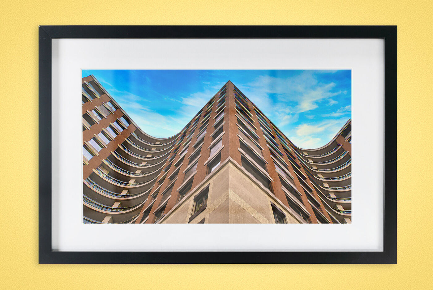 Ein modernes Gebäude mit geschwungener Fassade vor blauem Himmel